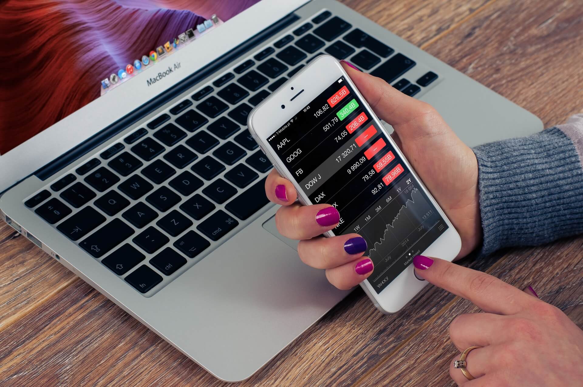 laptop and mobile phone with investment information