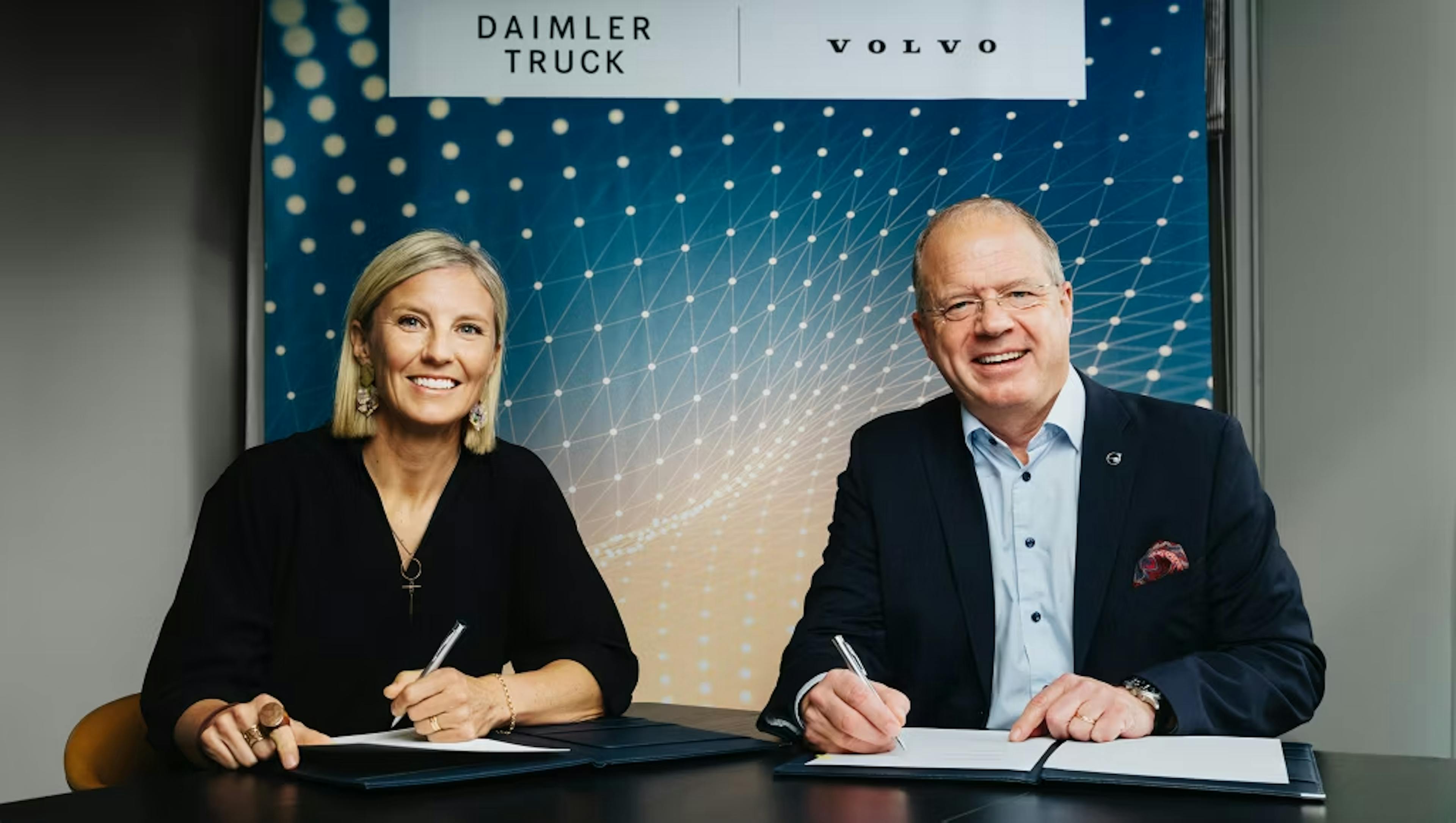 Executives from Daimler Truck and Volvo Group signing the joint venture agreement to develop a software-defined vehicle platform.
