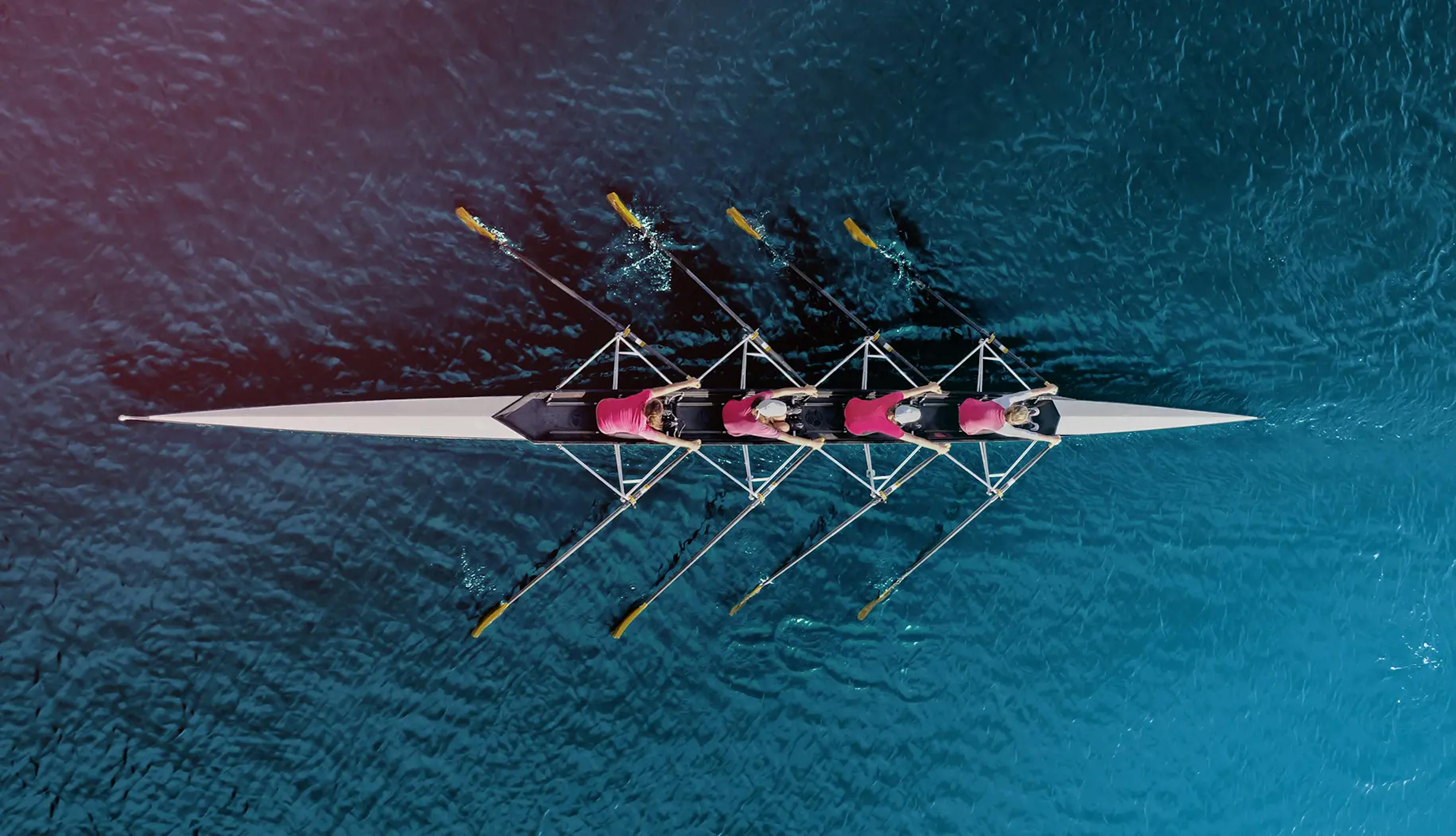 Aerial view of a rowing team in perfect sync, symbolizing high-performing teams, collaboration, and adaptive talent in motion.