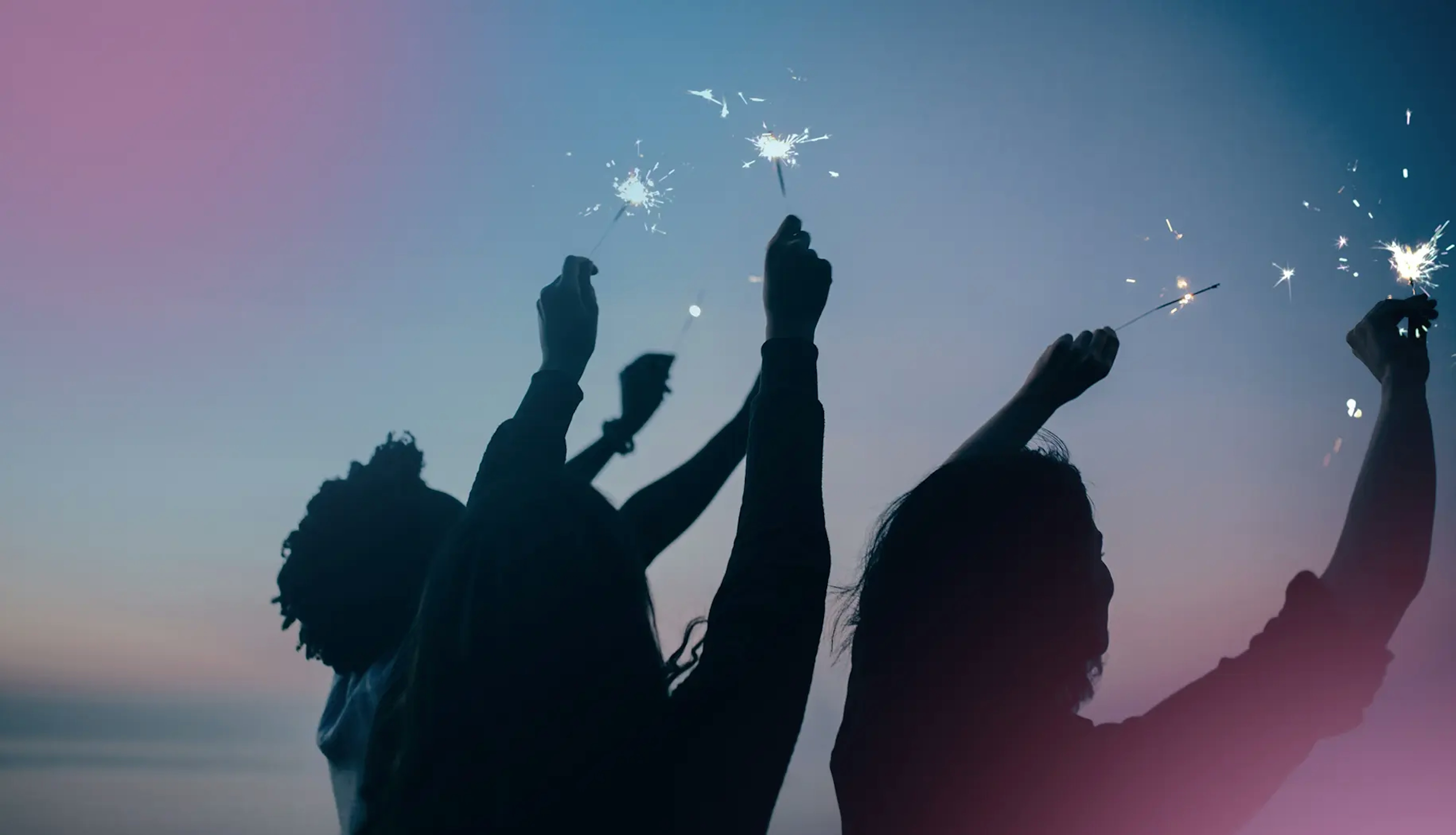 Silhouettes of people reaching toward glowing sparks in the sky, symbolizing empowerment, collective energy, and agile team spirit