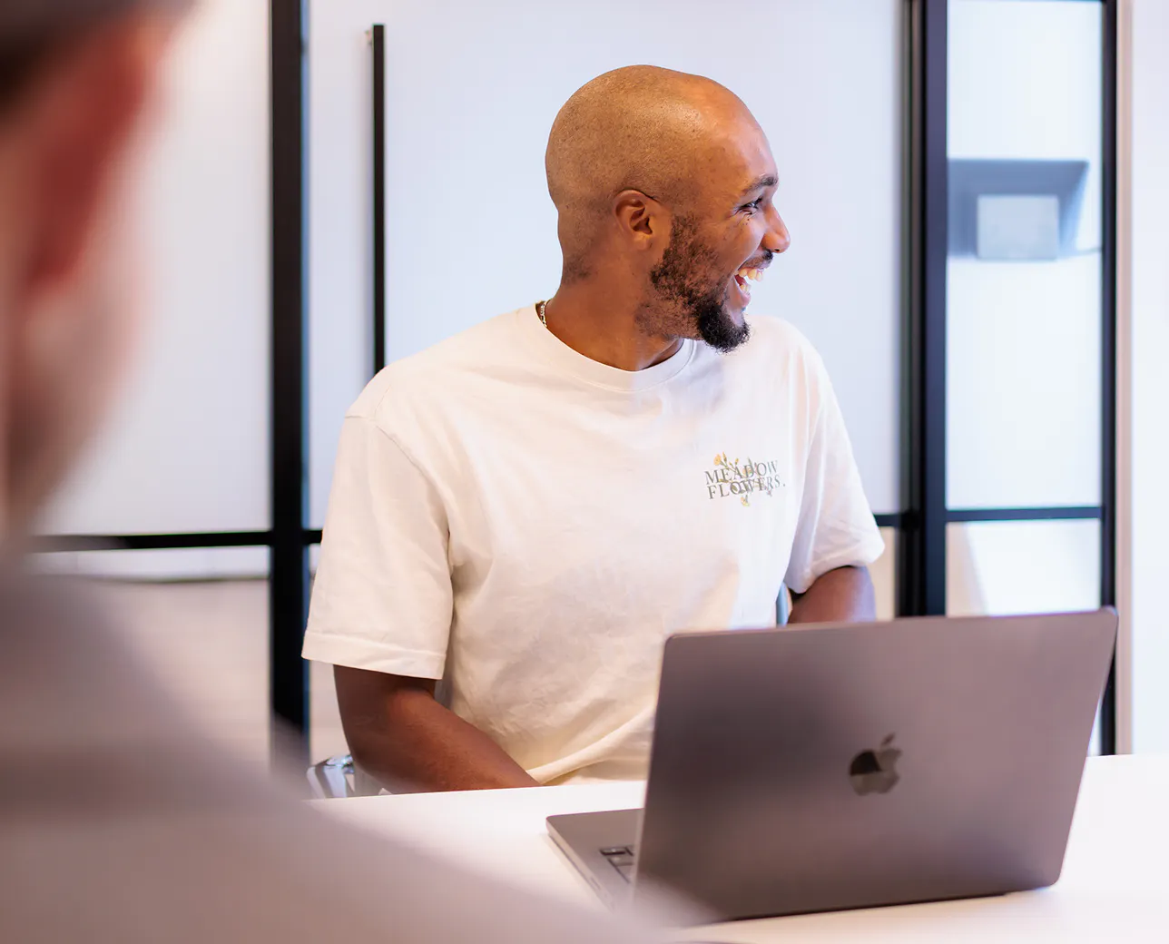 A man sat at a table on a laptop