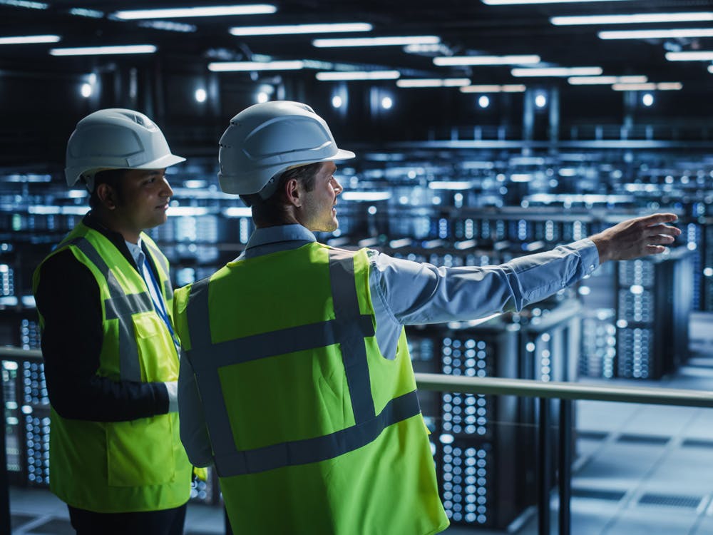 Two engineers working onsite in a data centre