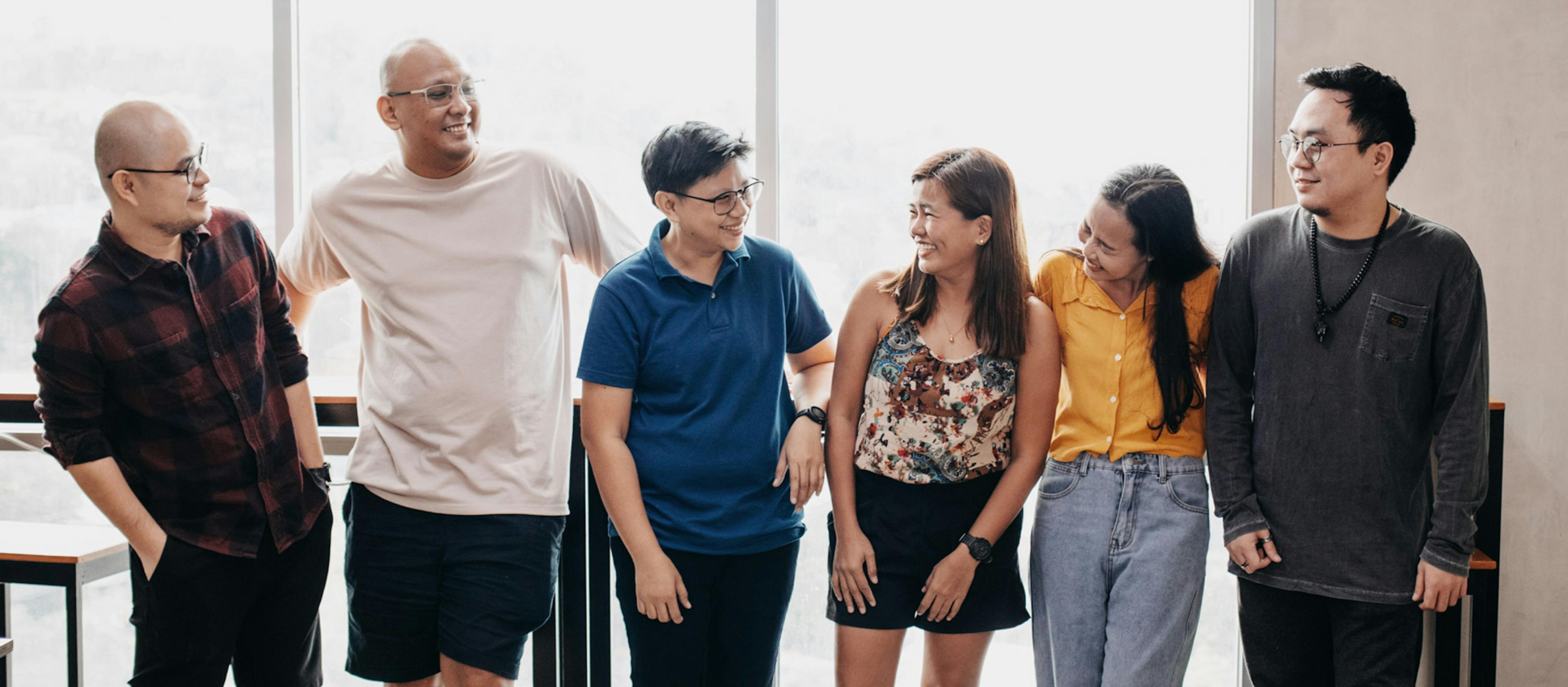 People looking at each other standing in an office