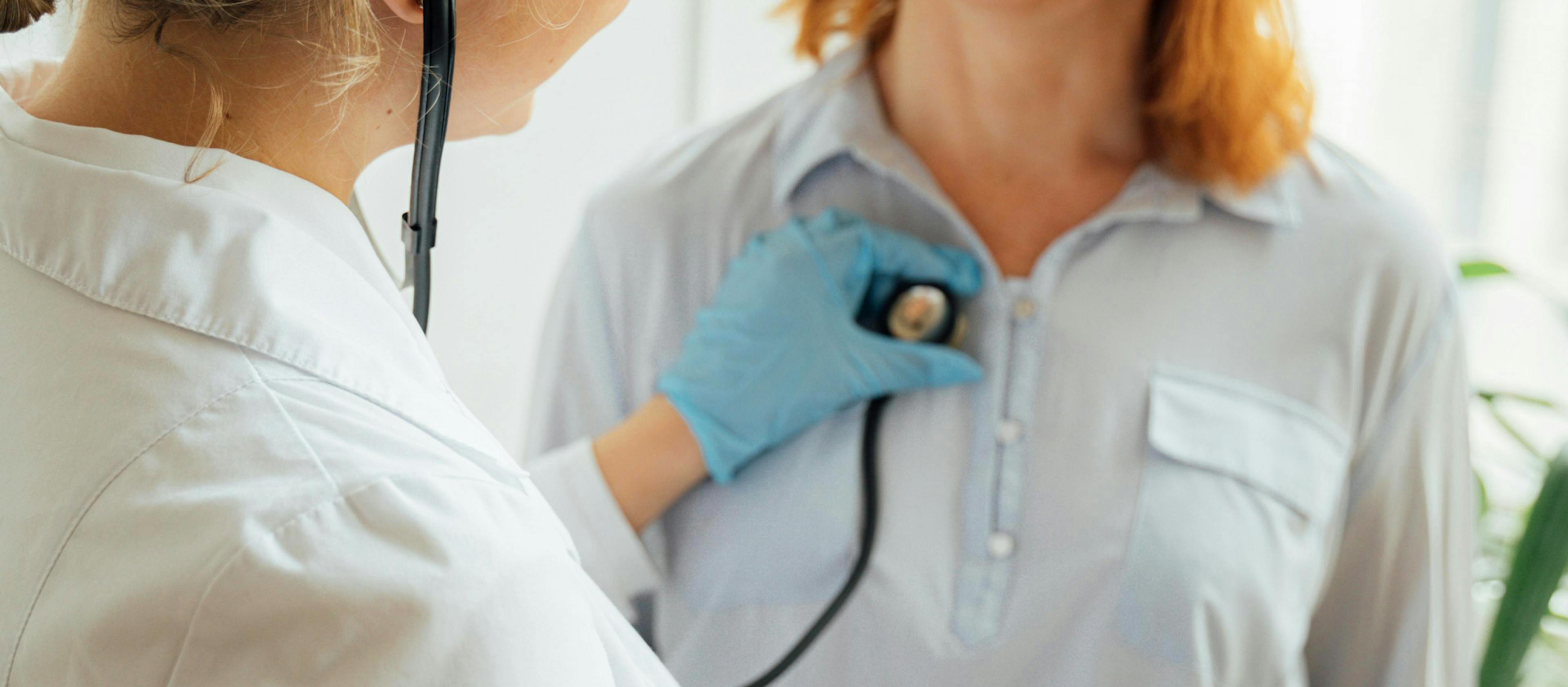 A medical professional listening to a person's chest using a stethoscope