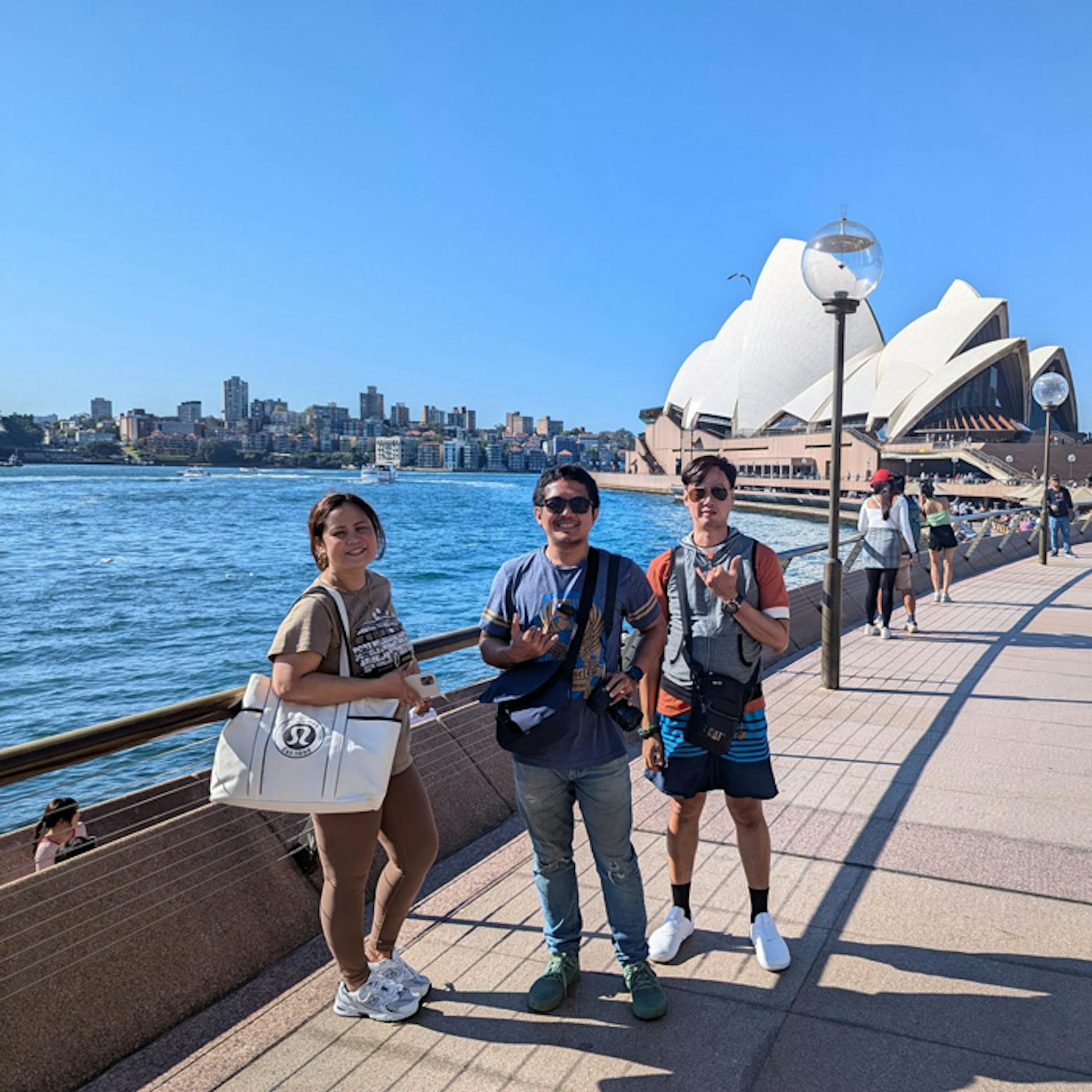 3 people posing near a body of water