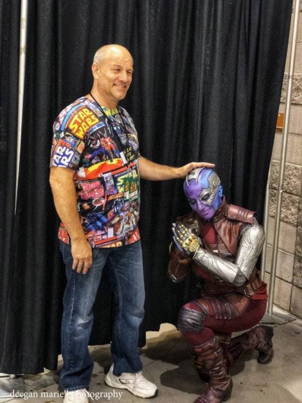 Cosplayer kneeling with handler standing