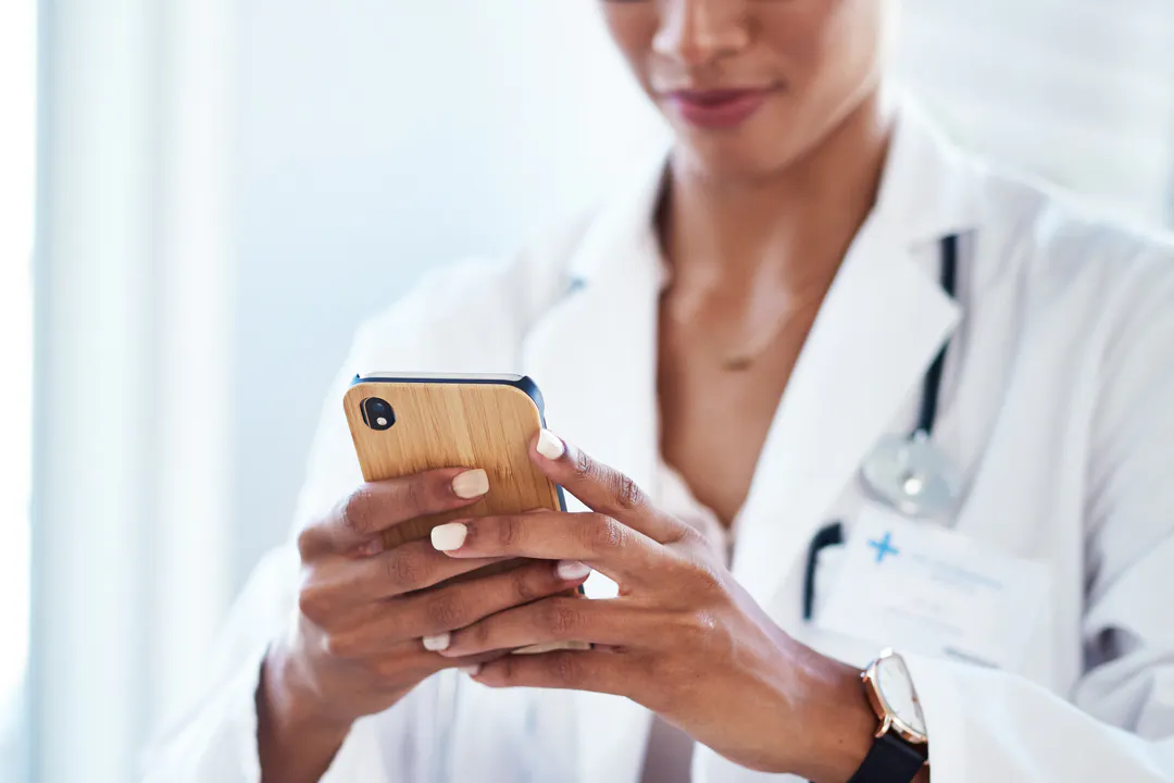 Female doctor looking at her mobile phone