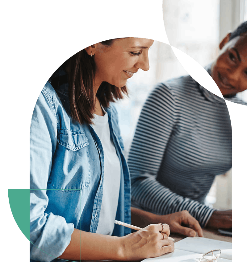 Small business owner with insurance reviewing her note book with a business partner