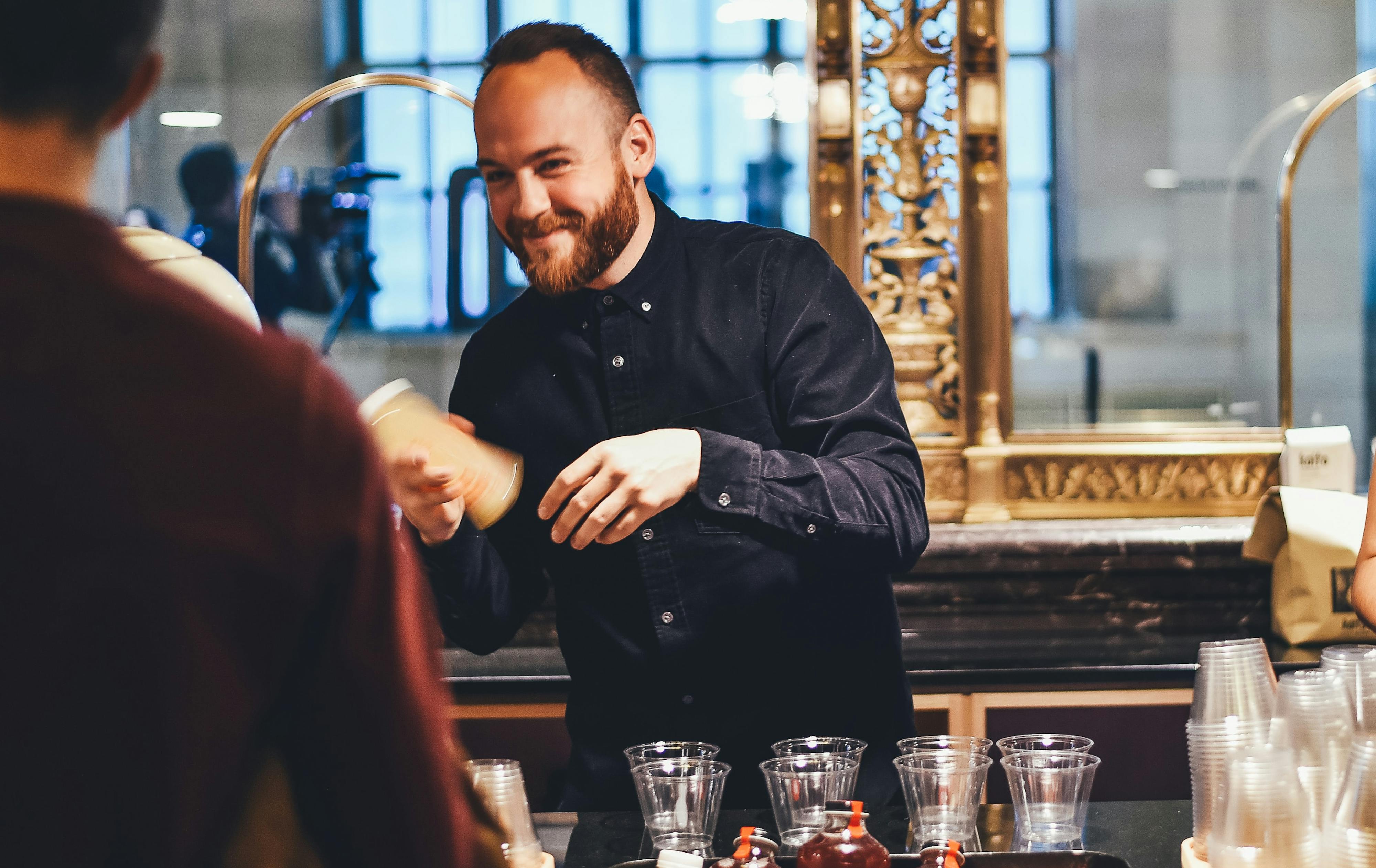 Small business owner making drinks behind a counter