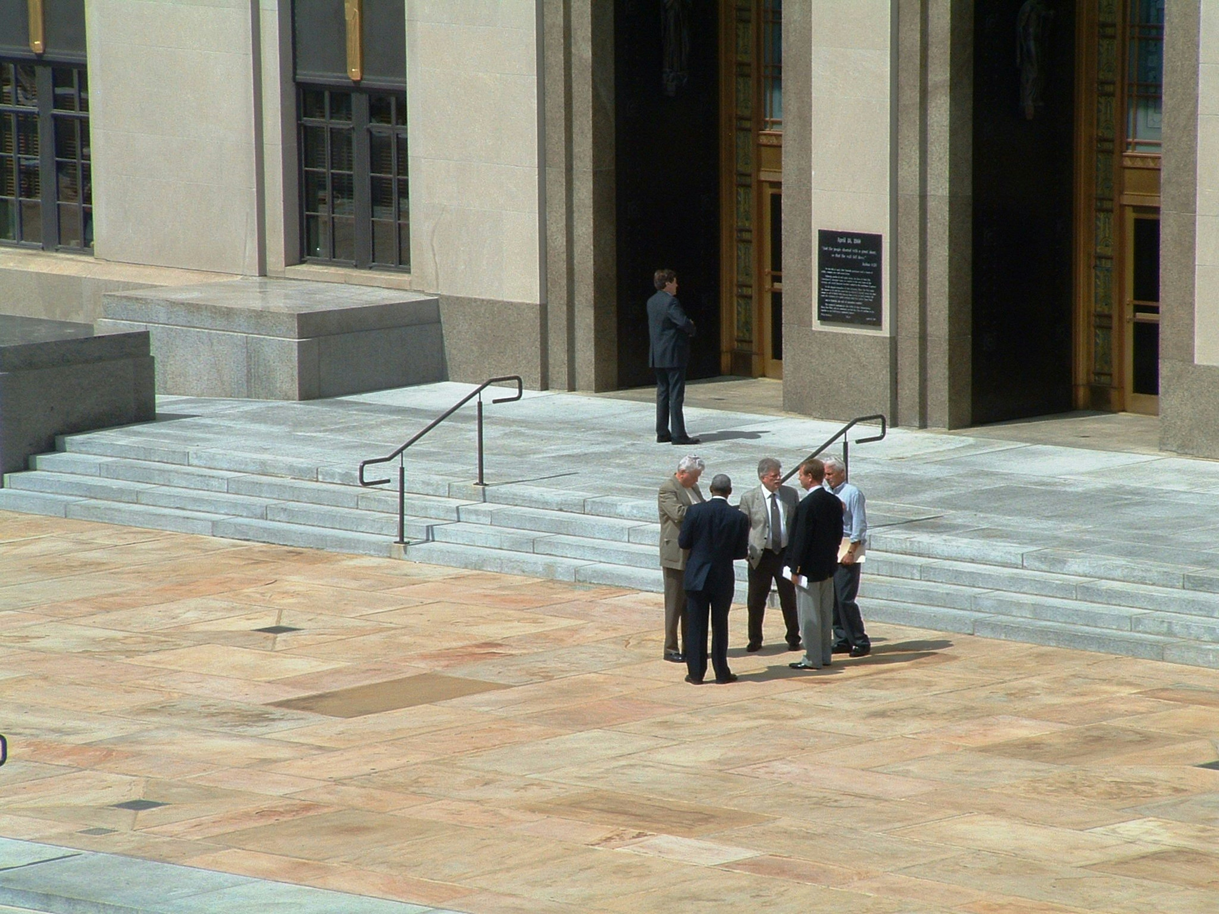 Men in suits standing outside of a court house