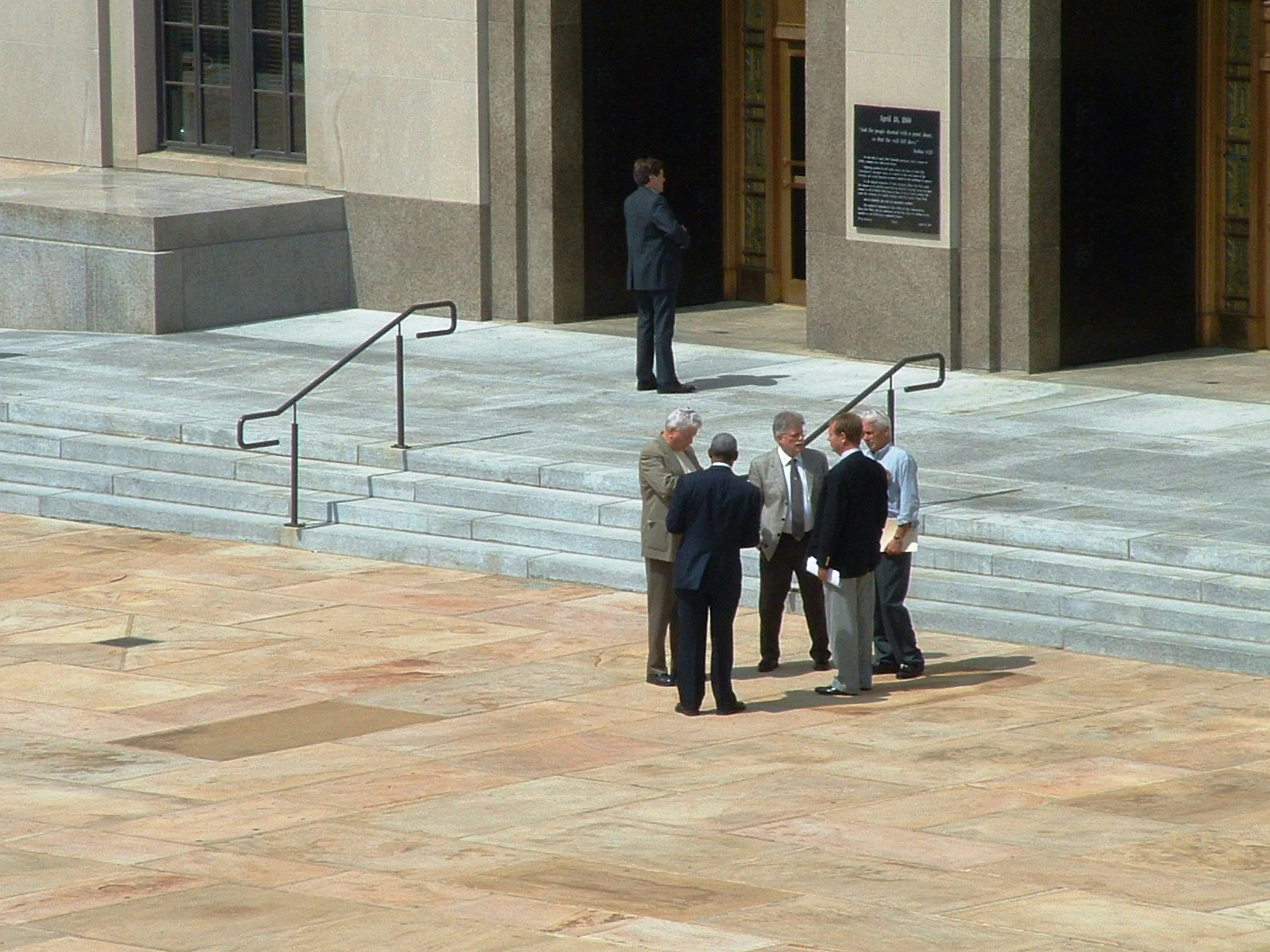 Men in suits standing outside of a court house