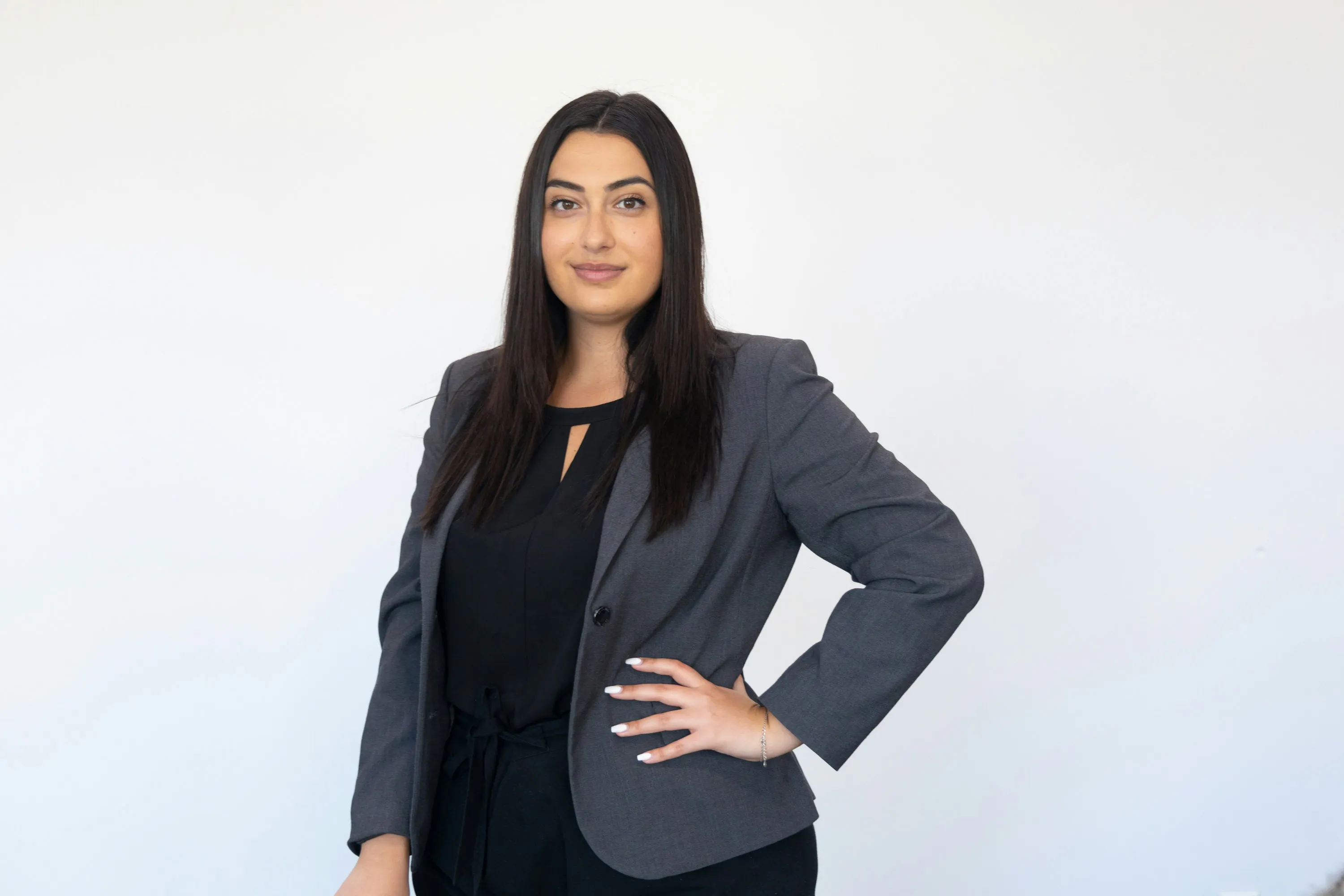 Woman in blazer standing with one hand an her hip
