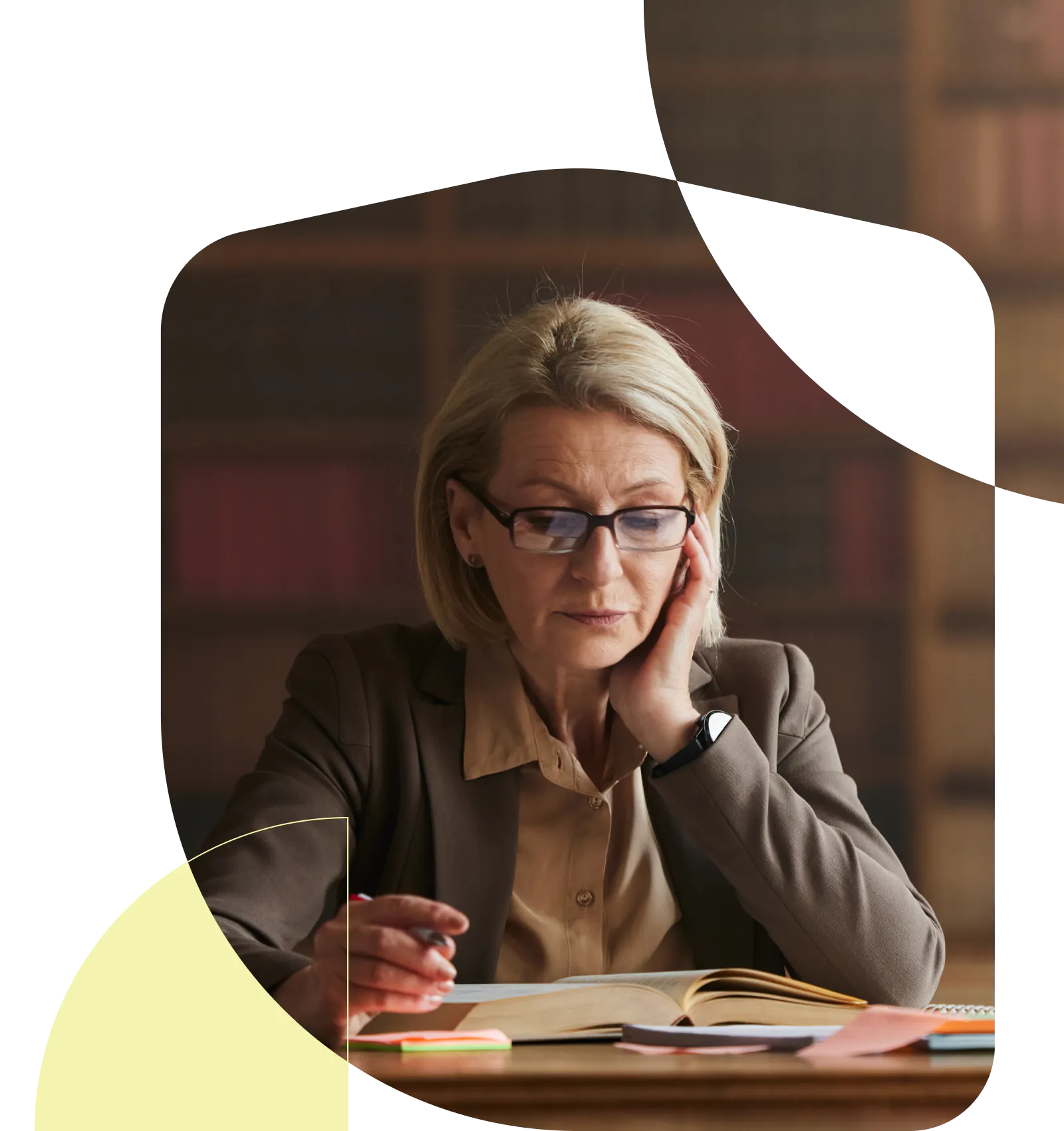 Women resting her chin on her hand, reading a book in a library 