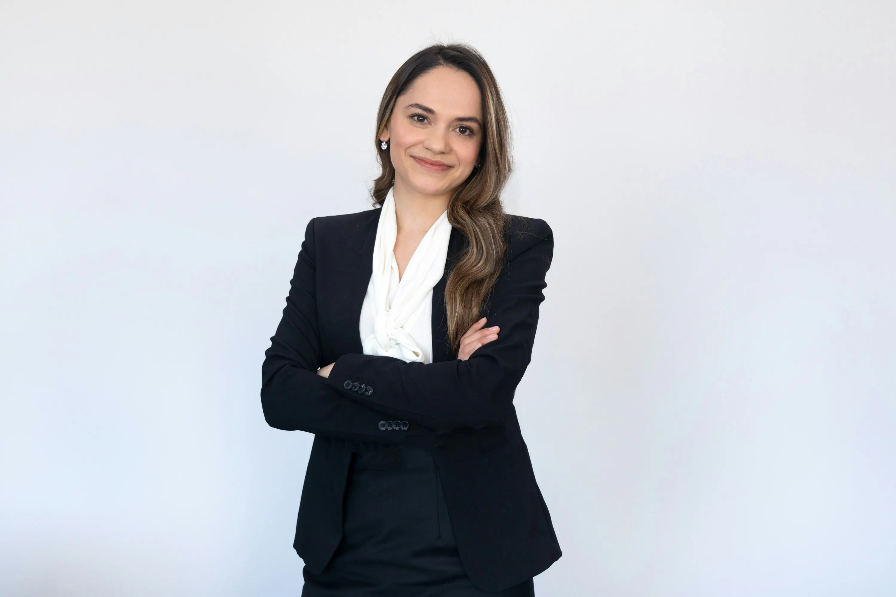 Woman in a suit standing with her arms crossed