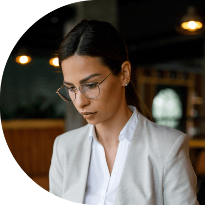 woman with glasses looking down and working