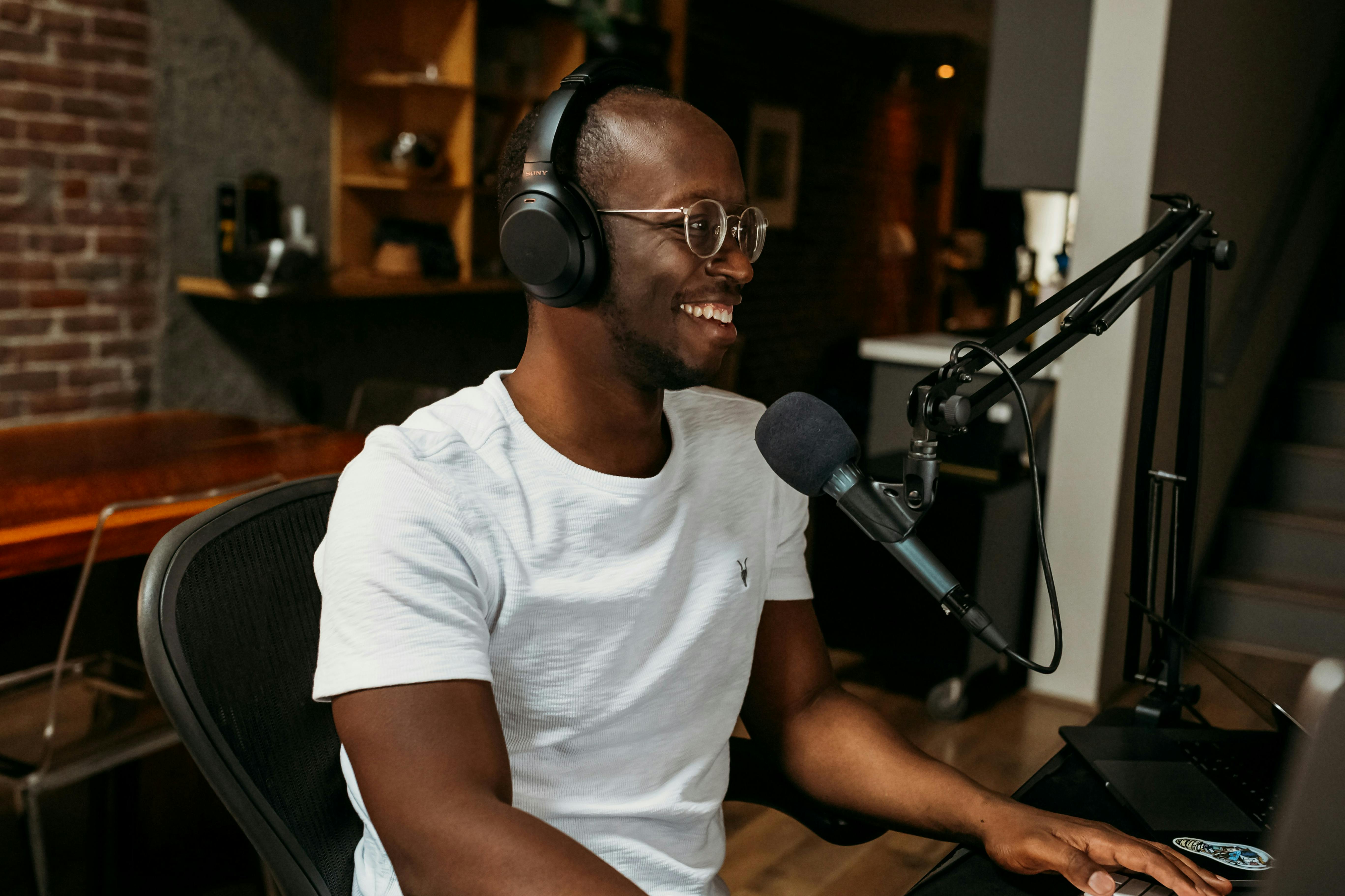 Man recording a radio show with a microphone and his computer