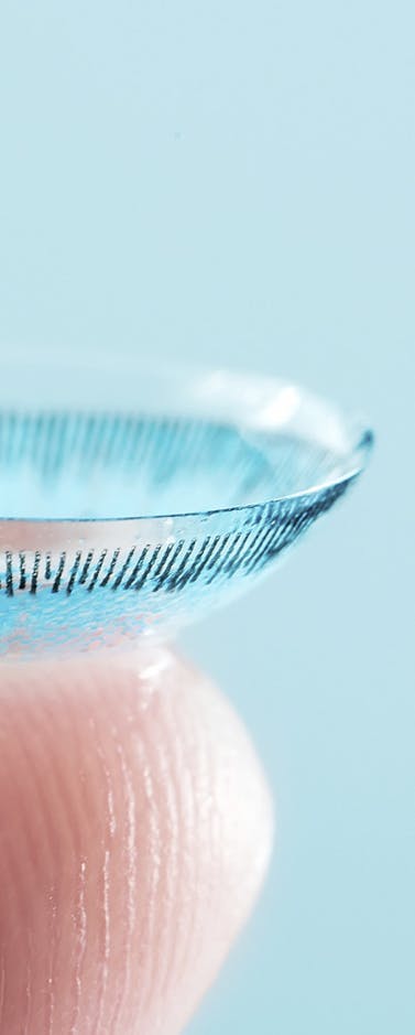 lentille de contact de couleur bleu sur le bout d'un doigt 