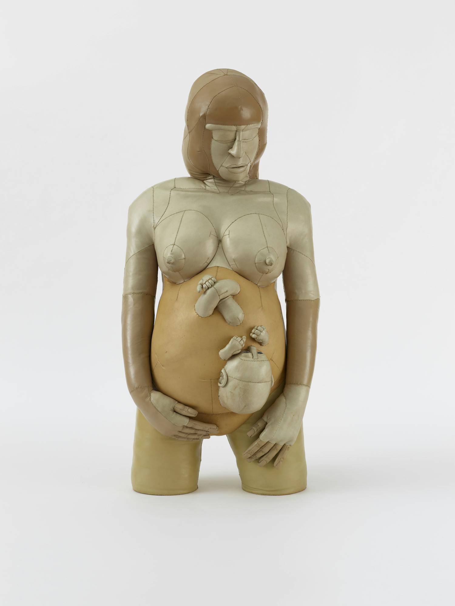 [ID: The image shows a sculpture of a pregnant woman, which is cut off at the middle of her thighs. A baby’s head, arms and legs are protruding from her stomach. The woman is looking down to the side, holding her stomach with one hand, the other hand by her left side. End of ID]