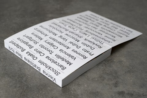 Back cover of the coworking spaces book featuring a collage of city names in various fonts with long and lat coordinates.