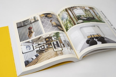 Magazine-style layout inside the coworking book with pictures of office spaces and design details.