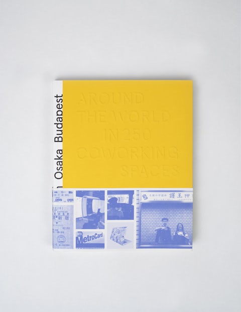 Top view of a book titled 'Around the World in 250 Coworking Spaces' with yellow cover and blue sleeve strip with photos and illustrations on the bottom.