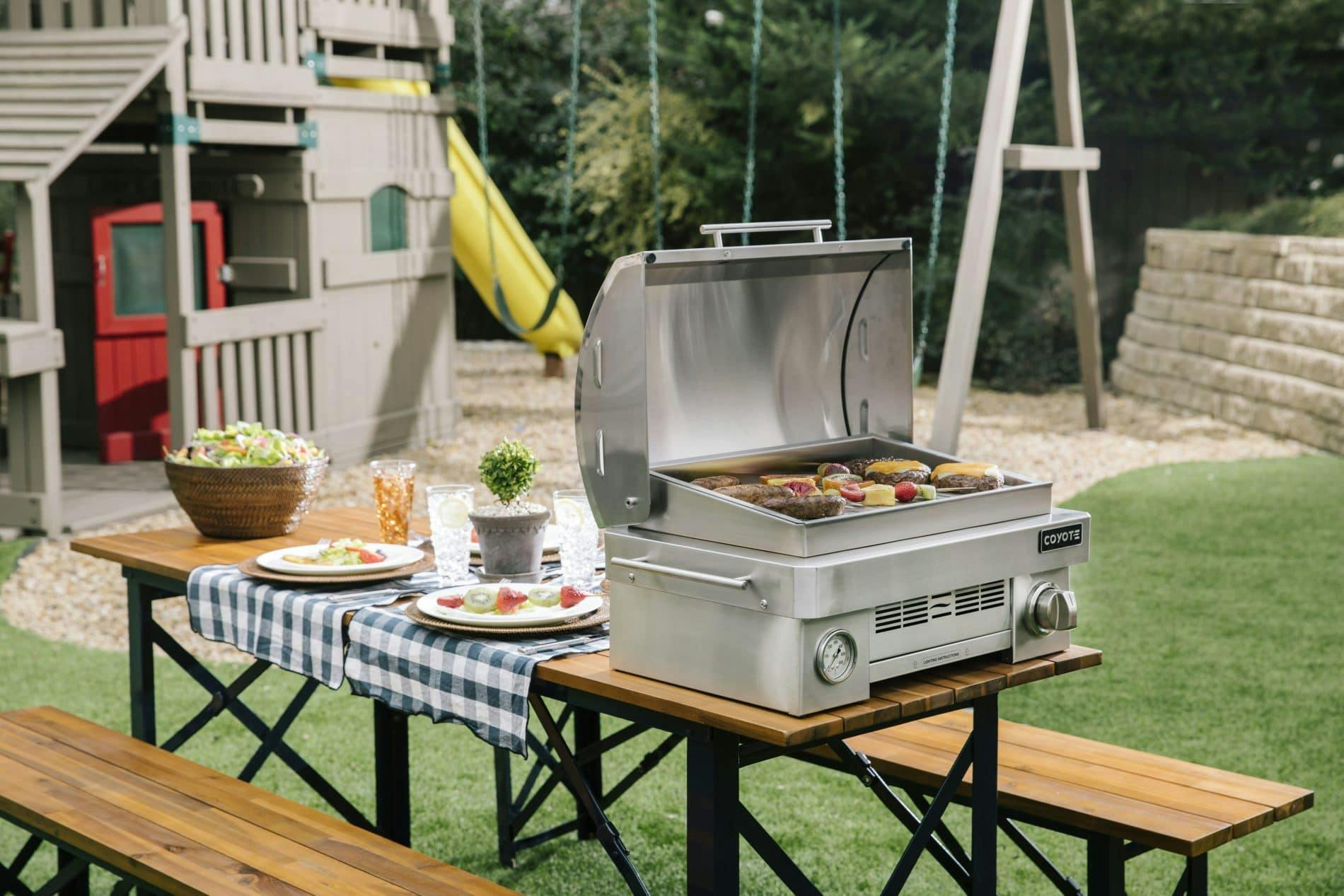 coyote portable grill being used in a backyard