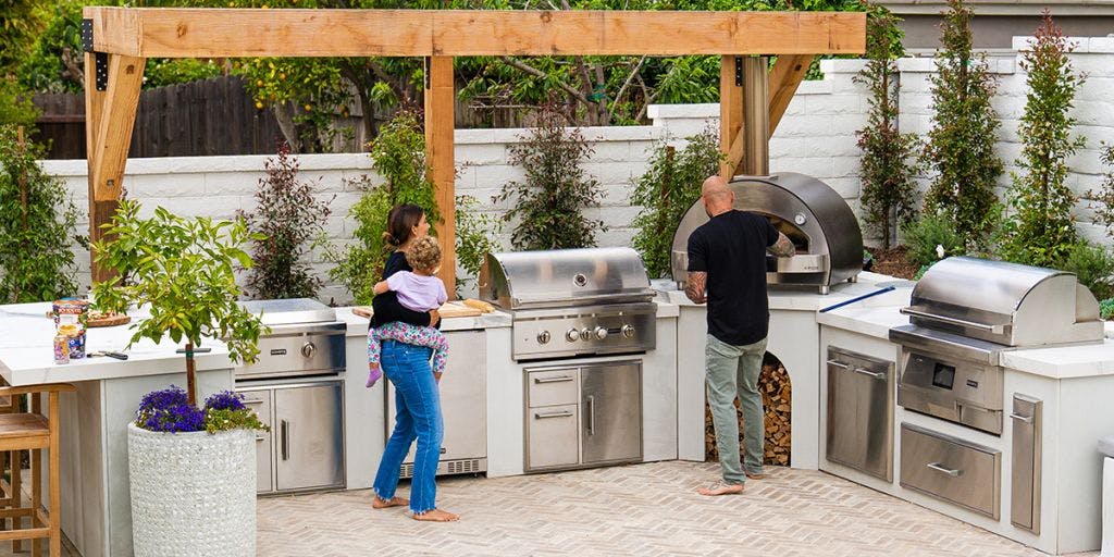 Family cooking dinner in beautiful custom outdoor kitchen