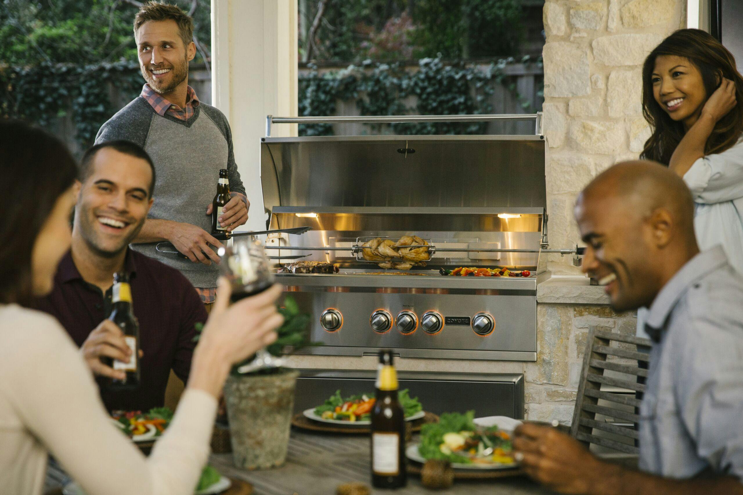 people grilling food on a coyote grill