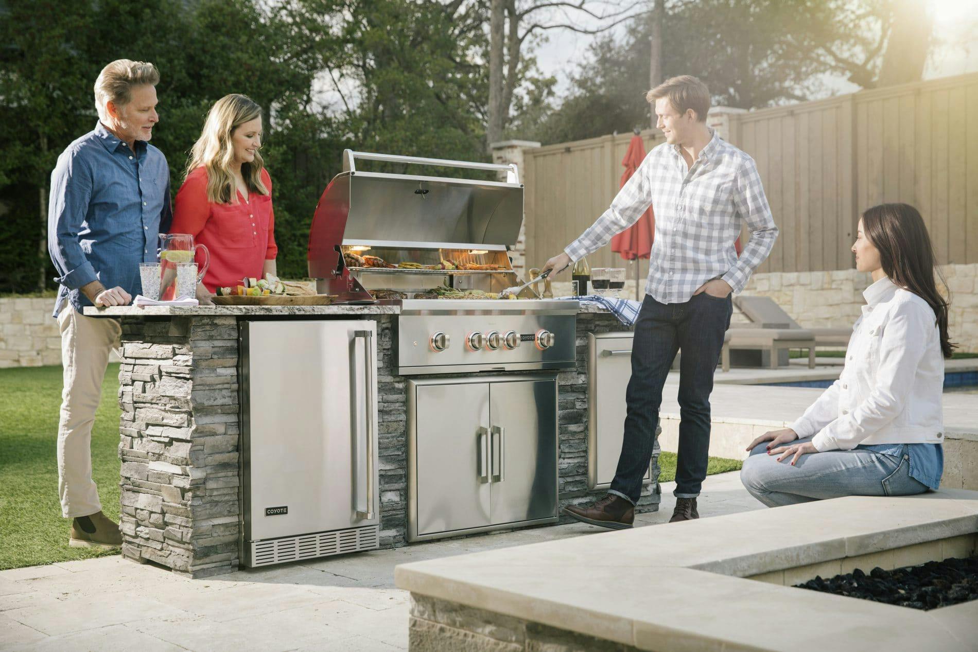 people grilling on coyote grill island