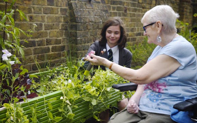 female student gardening with day centre resident