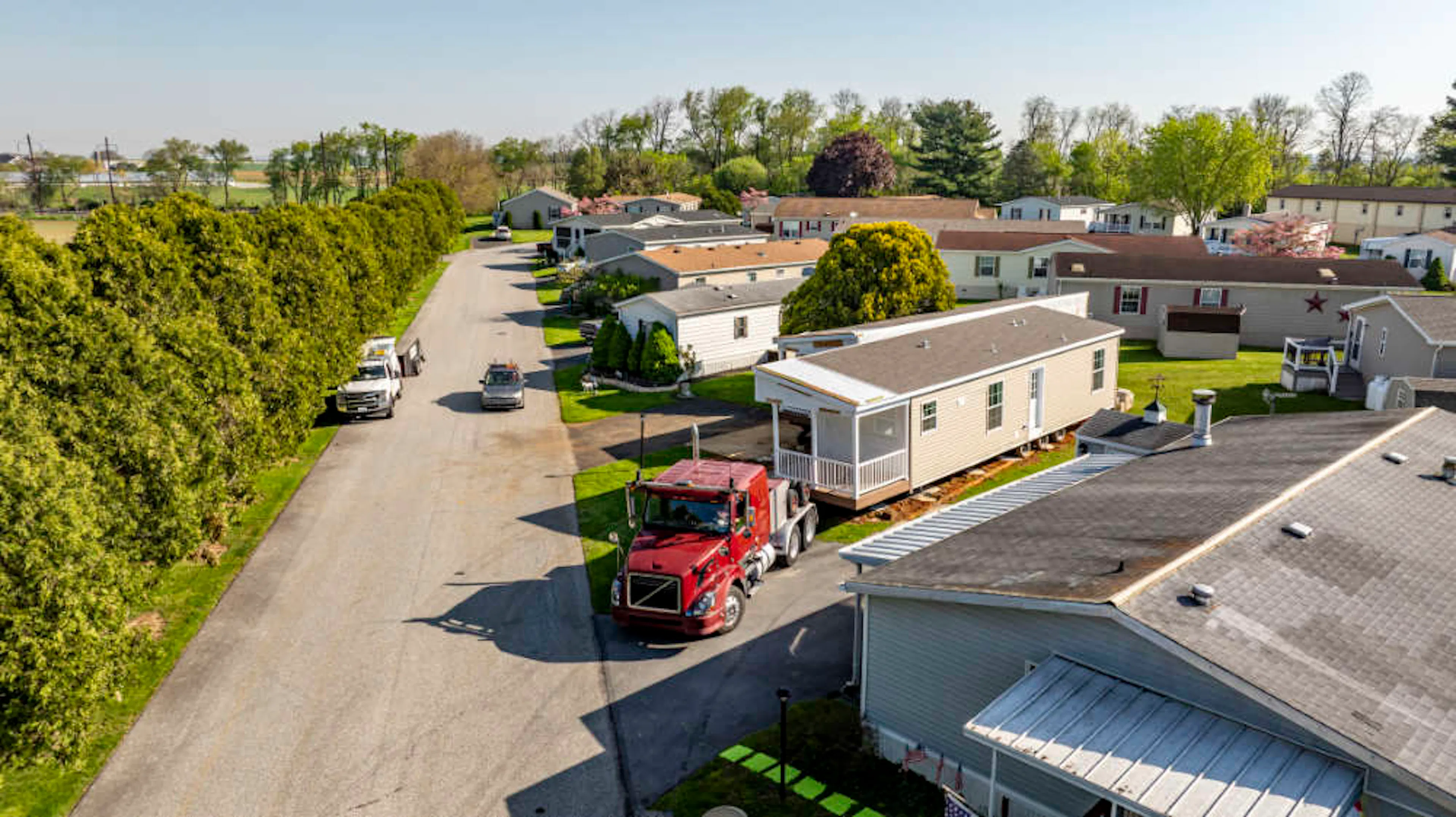 A truck delivers a manufactured modular home to a home site.