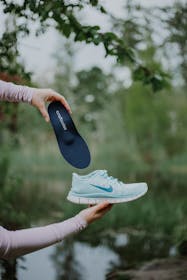 Frau steckt Einlage in Sportschuh