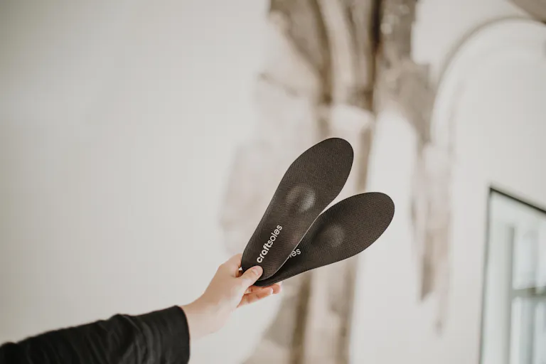 Frau hält Einlagen in die Luft