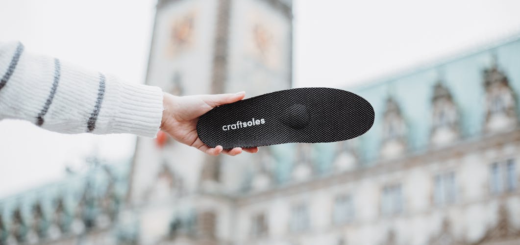 Frau hält Einlage von Craftsoles