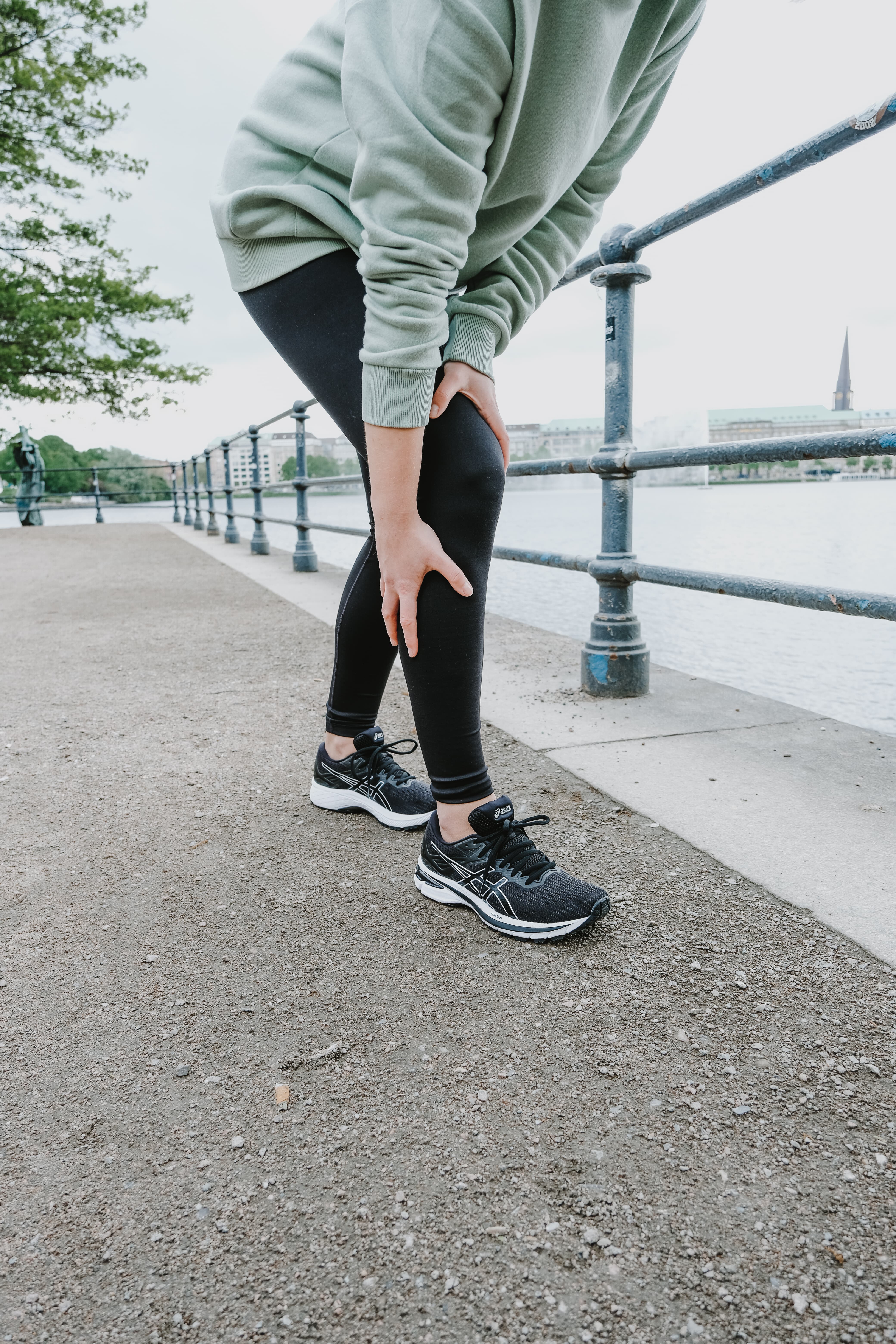  Frau greift beim Joggen an ihr schmerzendes Knie