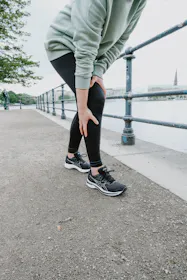  Frau greift beim Joggen an ihr schmerzendes Knie