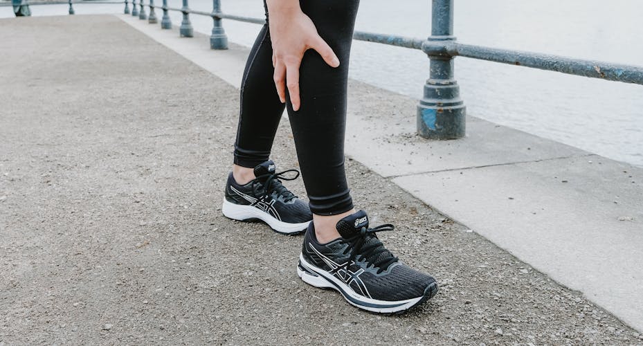 Frau greift beim Joggen an ihr schmerzendes Knie