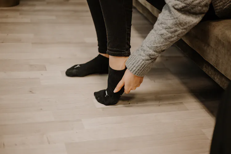 Frau hält sich schmerzende Hacke