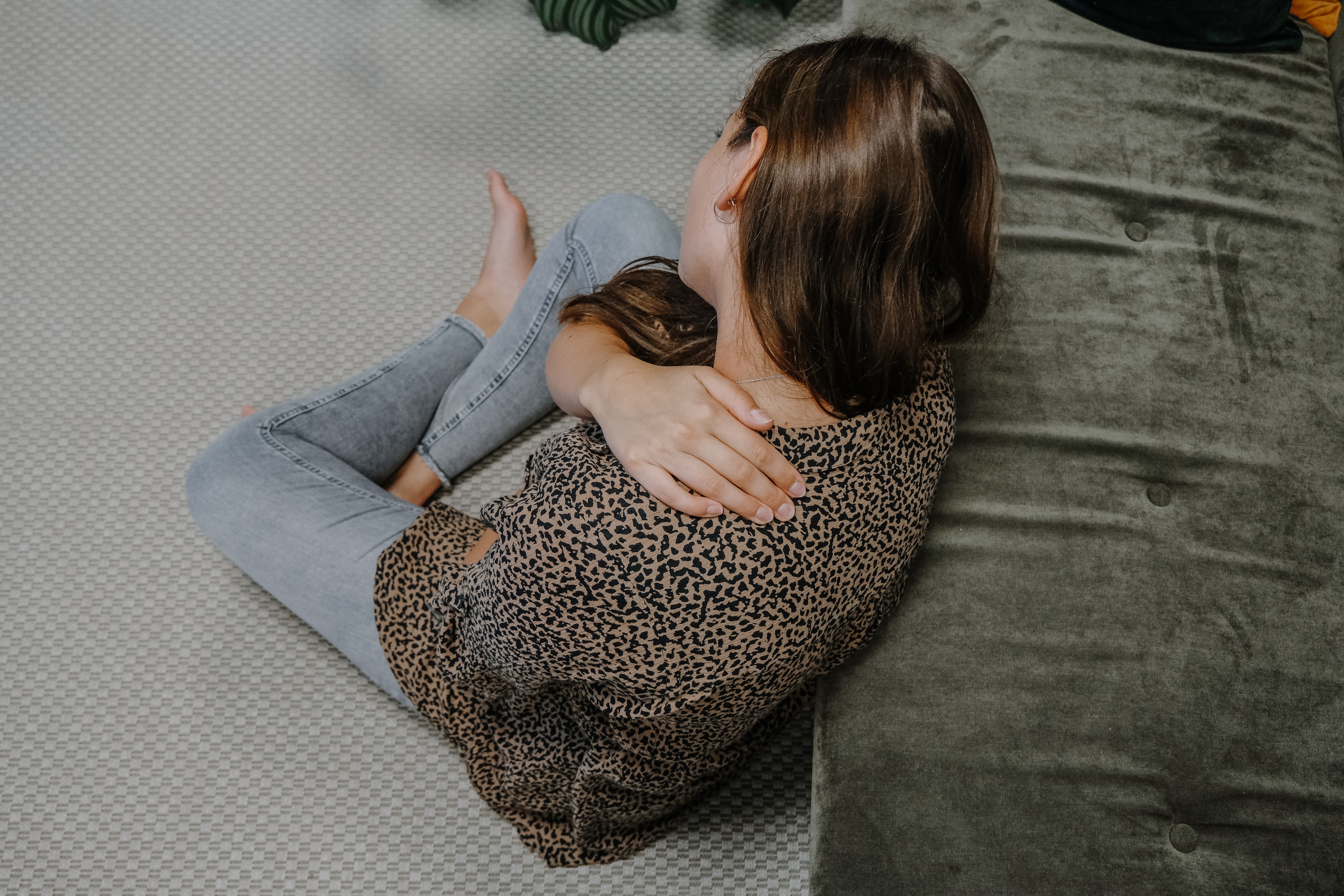 Frau hält sich Hand in den schmerzenden Nacken