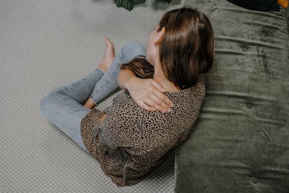 Frau hält sich Hand in den schmerzenden Nacken