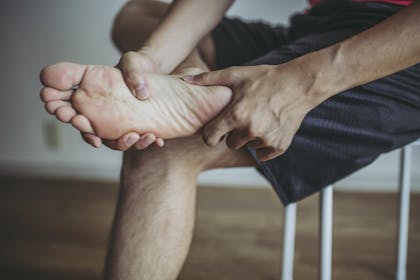 Mann greift sich an die schmerzende Hacke