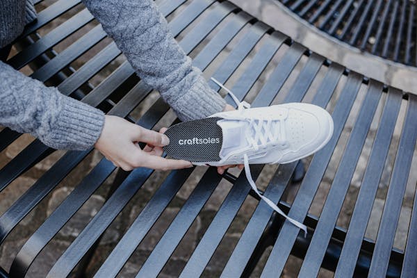 Frau steckt Einlage in Schuh