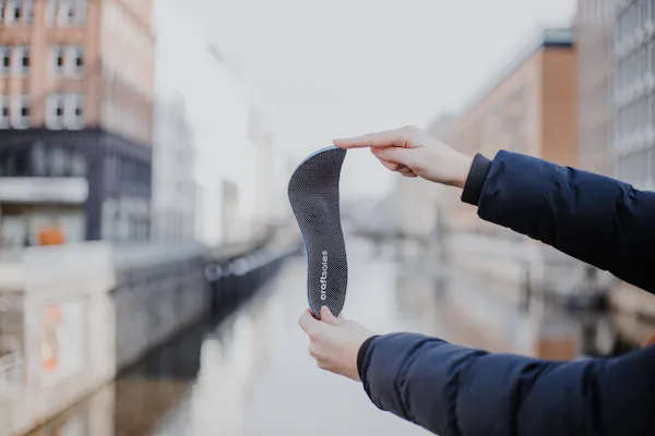 Frau hält Einlage in der Hand und knickt diese leicht