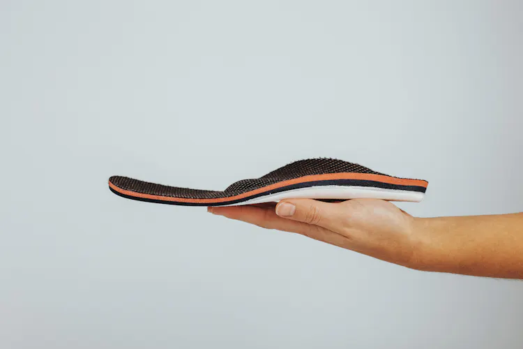 Mensch hält Einlage auf der Handfläche