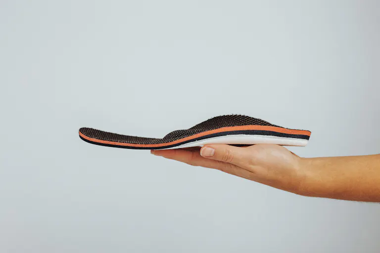 Mensch hält Einlage auf der Handfläche