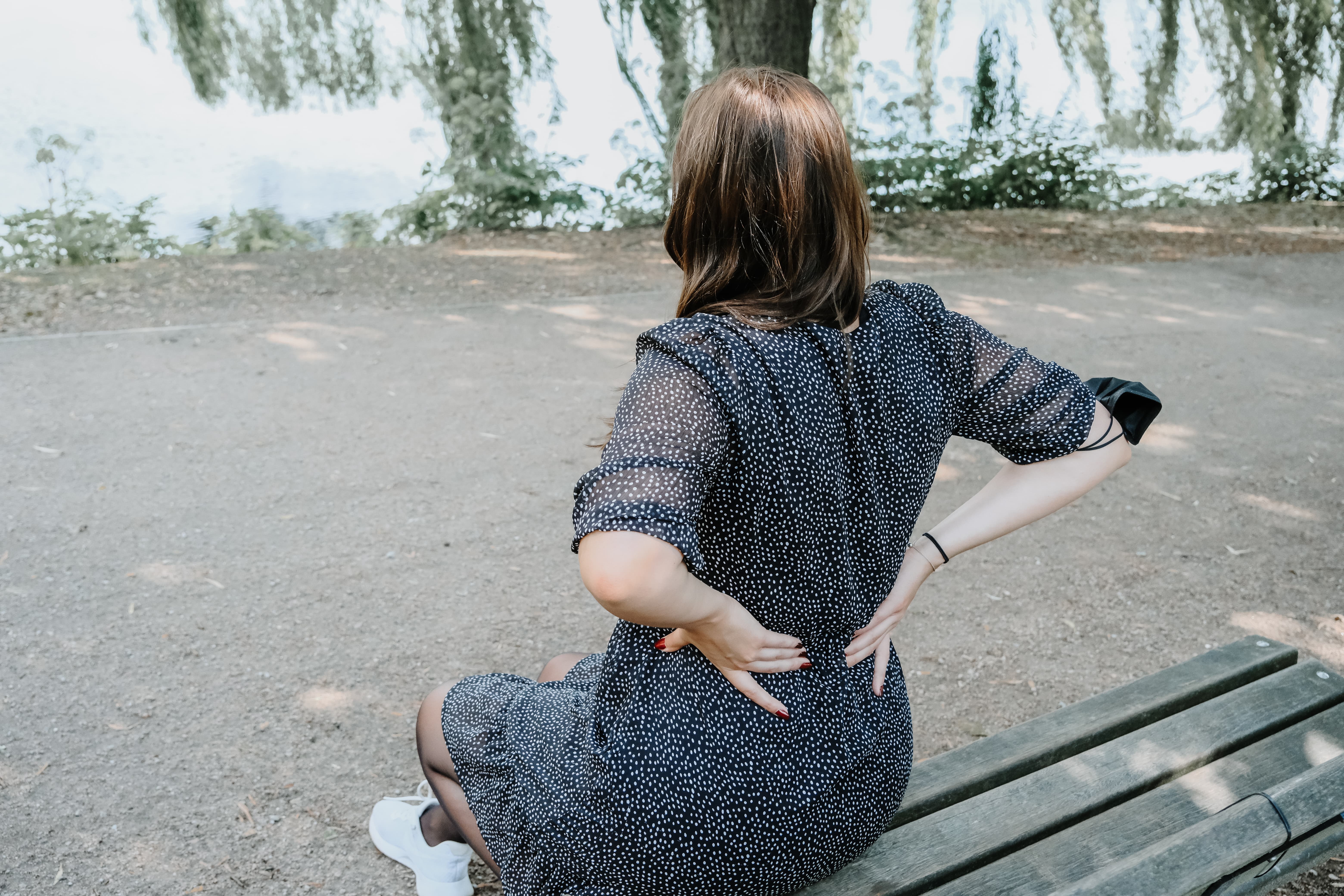 Frau hält sich den Rücken vor Schmerz