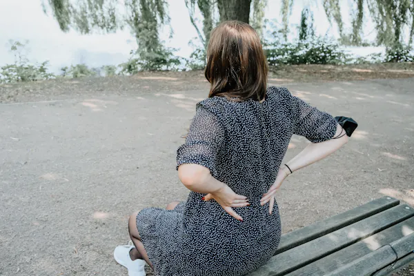 Frau hält sich den Rücken vor Schmerz