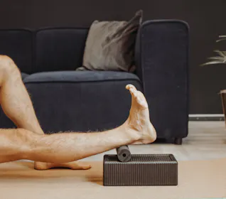 Mann macht Übung mit der Blackroll