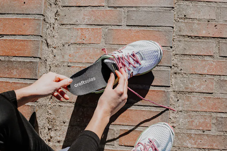 Frau steckt Einlage in Schuh