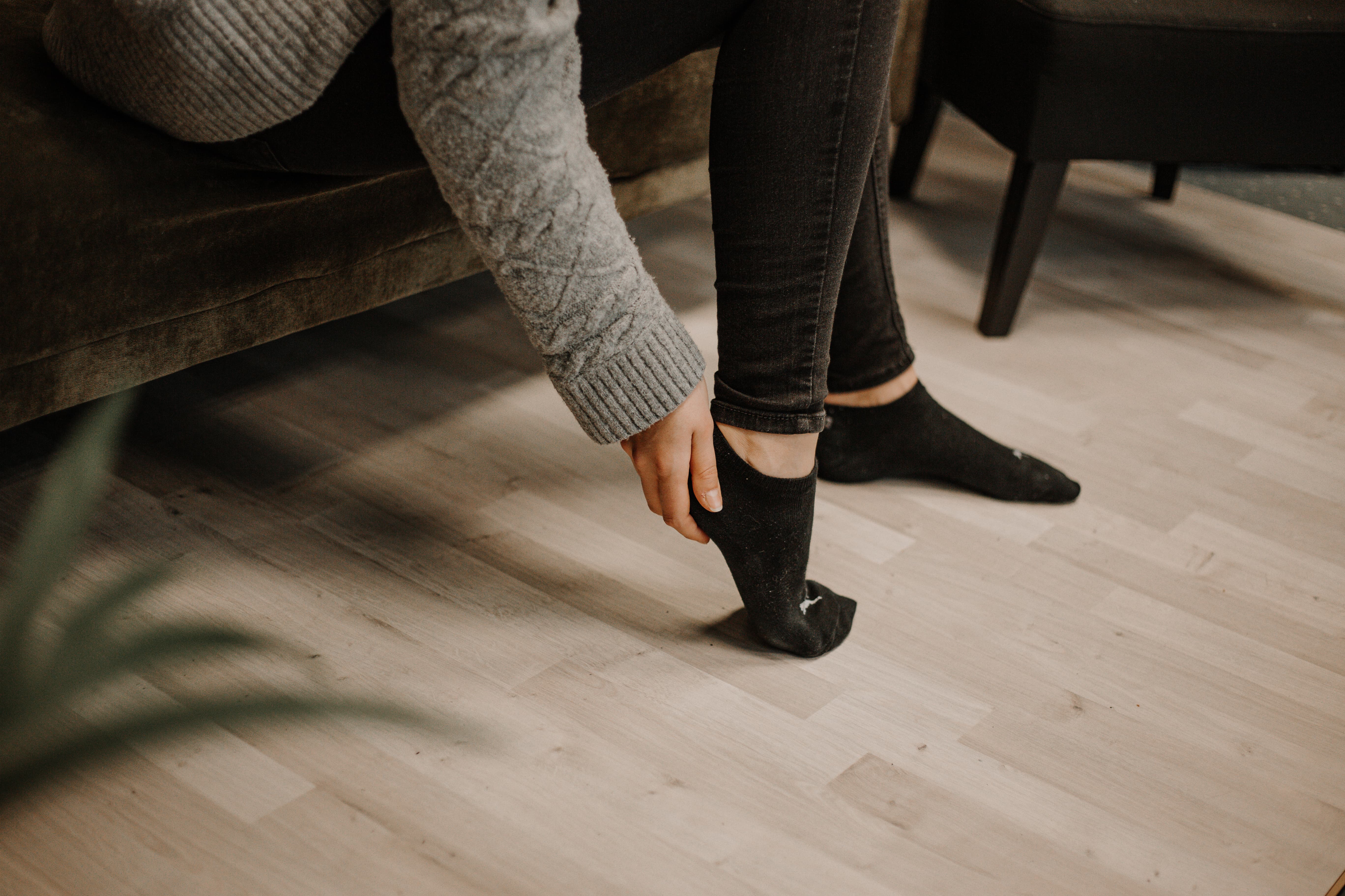 Frau greift sich an den schmerzenden Fuß